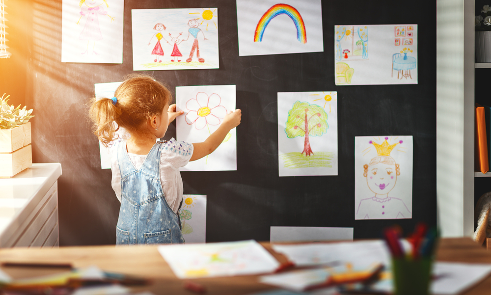 Child hanging her artwork ©Evgeny Atamanenko