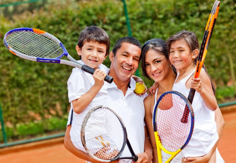 Family of 4 getting ready to enjoy a nice game of tennis